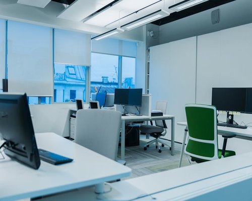 A modern corporate workspace in downtown Jakarta with bright ergonomic desks