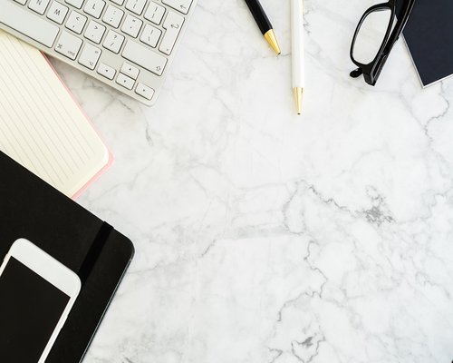 A person organizing a neat work from home desk setup with proper height adjustments